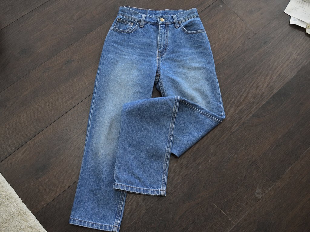 Vintage 90s Levi's 501 jeans flat-lay on darker wood