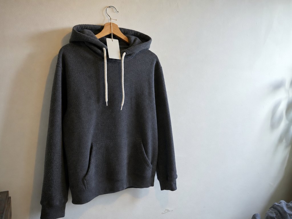 Kids' charcoal grey hoody hanging on a wooden hanger